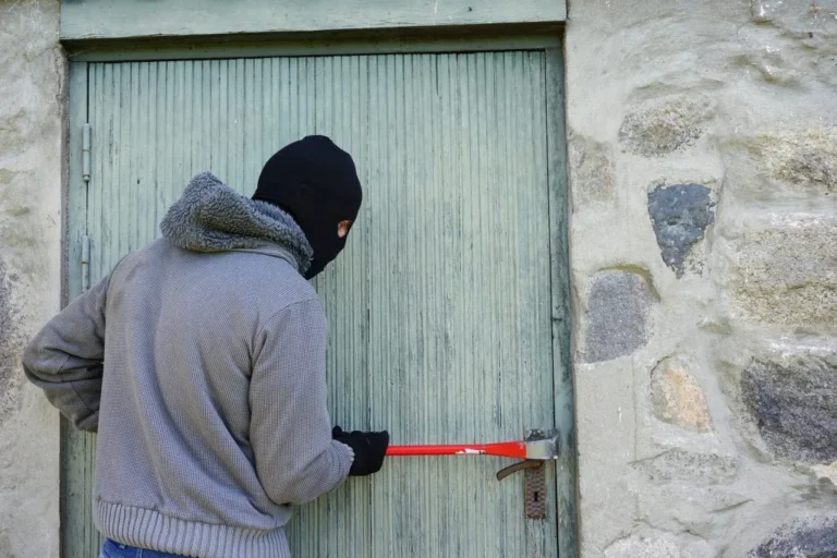 Einbrecher mit Brecheisen vor Tür