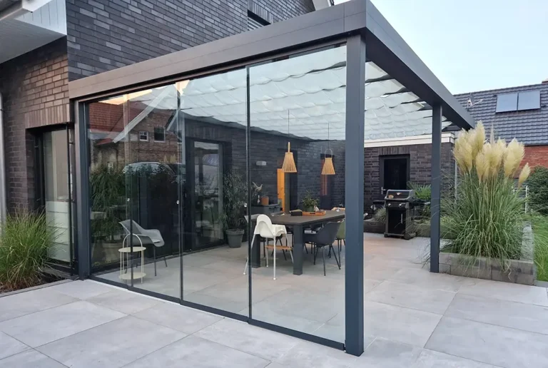 Anthrazitfarbene Aluminium-Terrassenüberdachung mit geschlossenen Glasschiebewänden auf moderner Terrasse